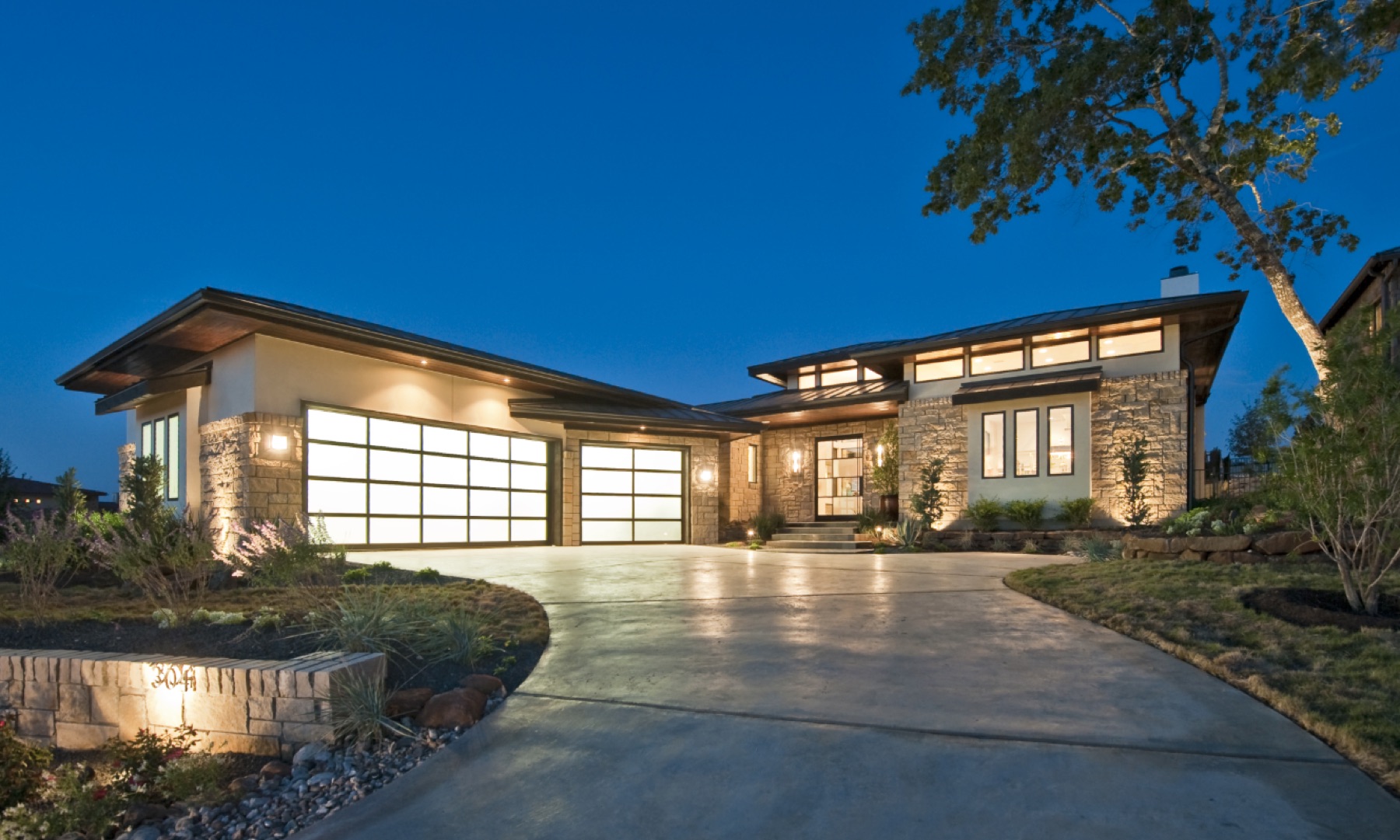 Contemporary prairie-style custom home illuminated at dusk