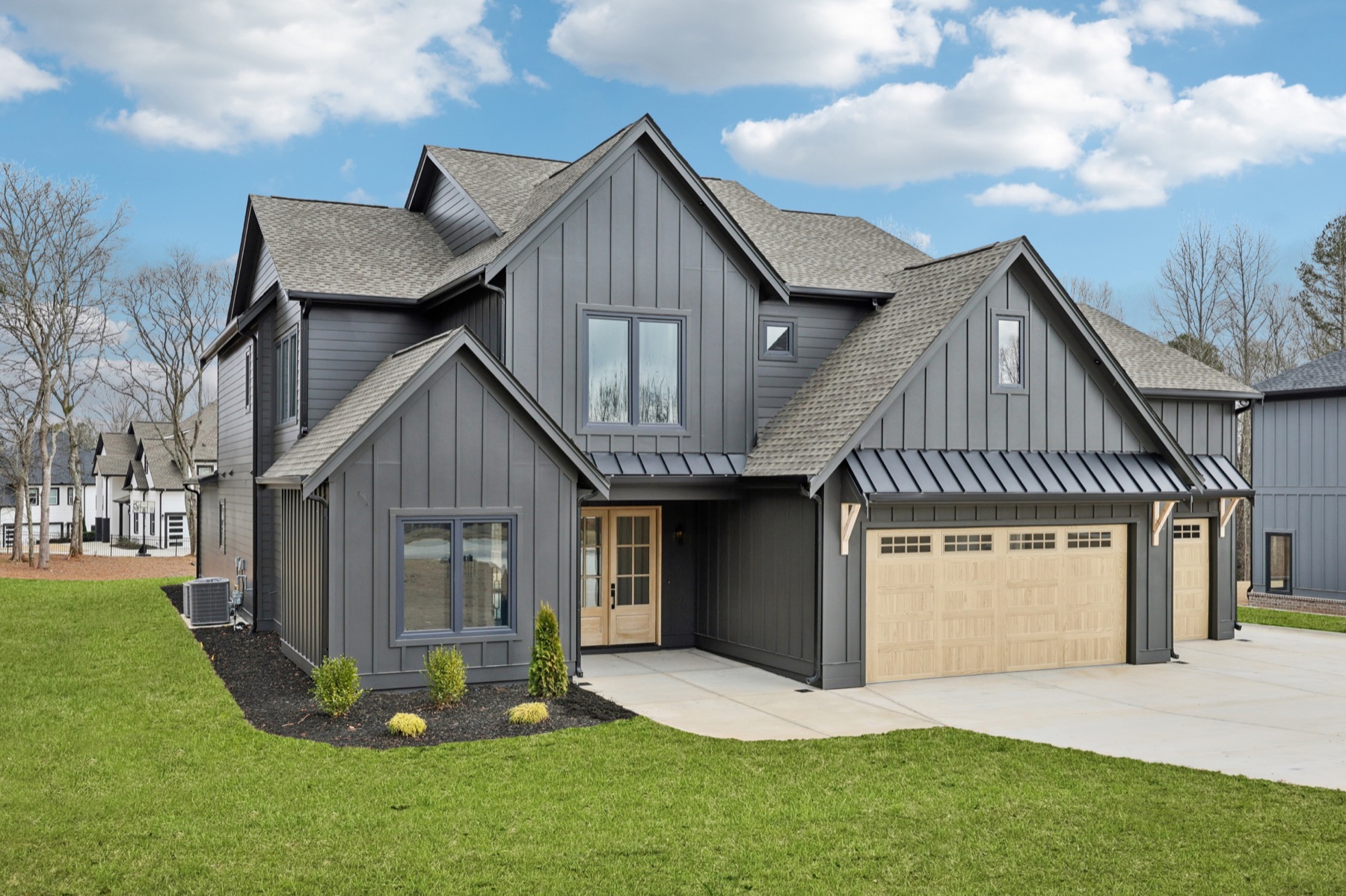 Custom modern farmhouse exterior with board-and-batten siding and three-car garage